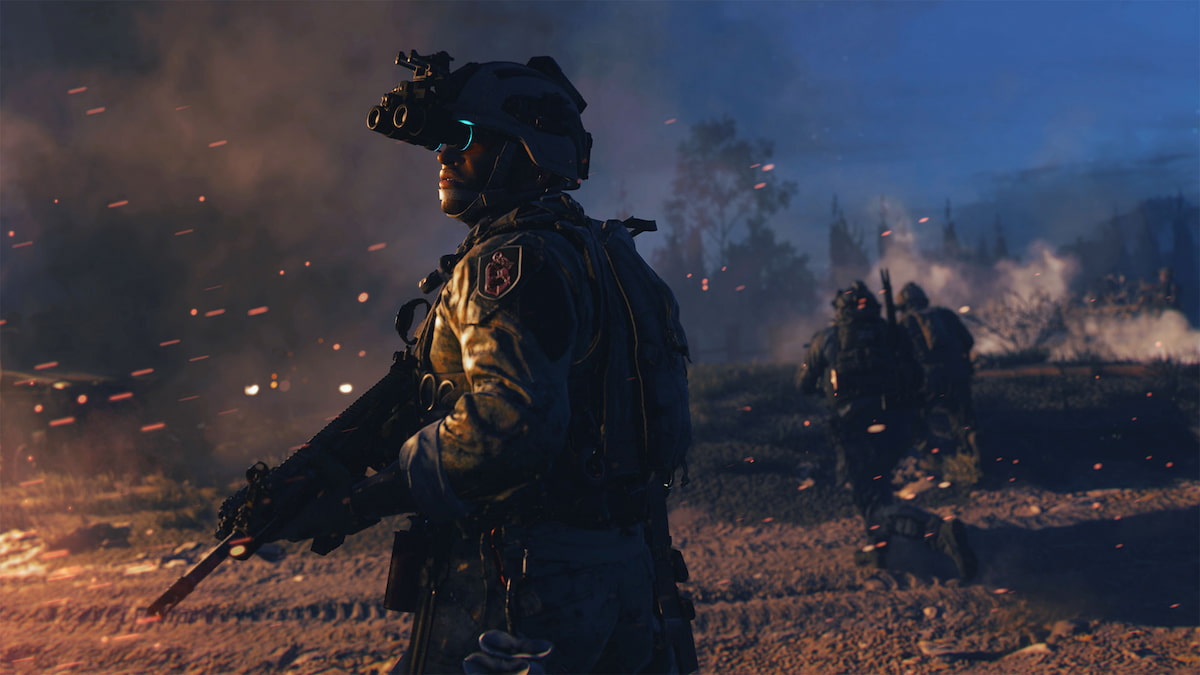 Call of duty Modern Warfare 2 (MW2) Soldier stands and looks at some burning wreckage to the left. He wears goggles to see better. Another walks ahead and both are in the desert.