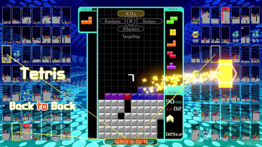 Tetris-99-gameplay is a screenshot of gameplay from the video game Tetris 99. The image shows a Tetris game board with various Tetriminos (Tetris shapes) falling from the top of the screen.