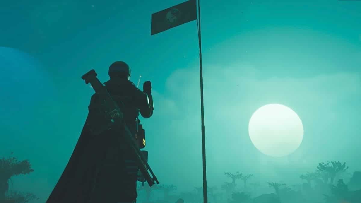 Helldivers 2 player salutes the flag in the moonlight.